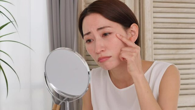 目尻とほうれい線のシワに悩む中年の女性