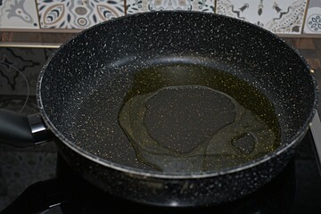 frying pan with vegetable oil on electric stove