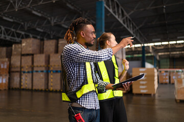 Warehouse manager talking and using digital tablet while checking product in warehouse, Logistic...