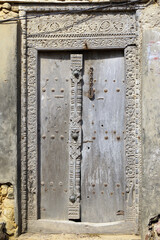 Intricately carved wooden door with metal studs