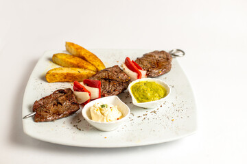 A plate of food with meat, potatoes, and a sauce