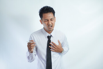 Unhealthy young Asian businessman got chest pain when smoking isolated on white background