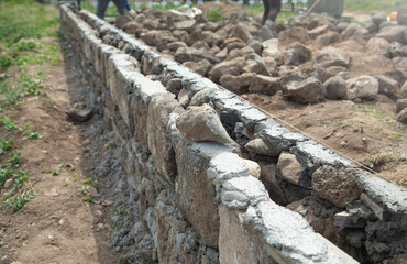 Unfinished rough stone wall in outdoor. Construction