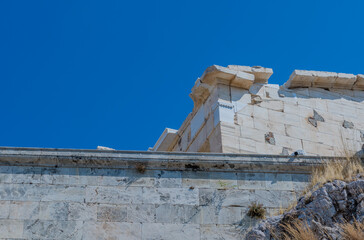 The imposing ruins of the Parthenon atop the rocky Acropolis under a bright blue sky in Athens...