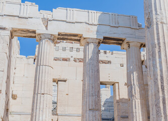 Ancient Greek temple facade with towering columns and stone blocks, in Athens Greece