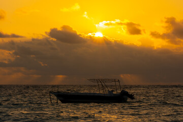 Fototapeta na wymiar Small boat on the sea at sunrise in Punta Cana