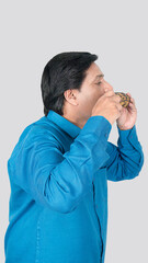 portrait view of a man eating tasty and delicious corn cob seeds.