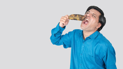 a young boy eating corn cob like crazy way with his facial expression. copy space on left sides