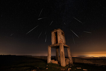 Perseid star shower over the ruins of a watchtower at the top of Picon Blanco, Espinosa de los...