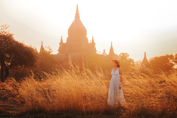 women standing and looking at Bagan temple in Myanmar archaeological zone at sunset.