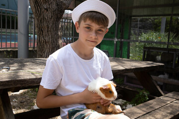 Boy holding a guinea pig in his arms