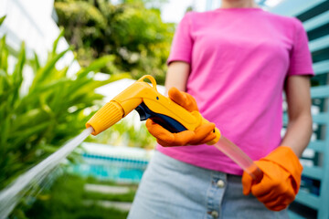 A young woman takes care of the garden, waters, fertilizes and prunes plants - 790582396