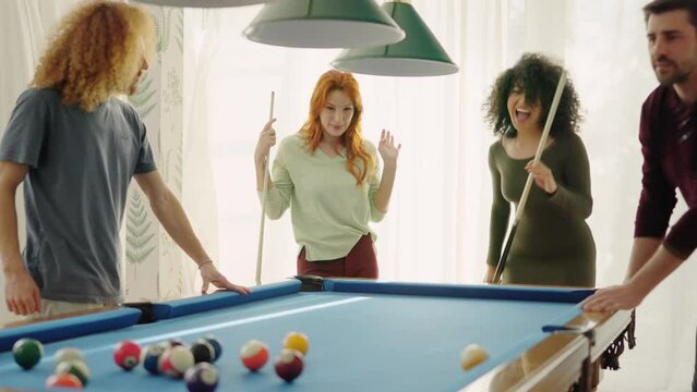 Beginner player hitting a billiard ball and laughing happy