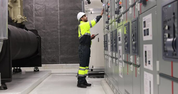 Industrial engineer or electrical engineer with PPE check control panel in HVAC control room, Industrial  Factory