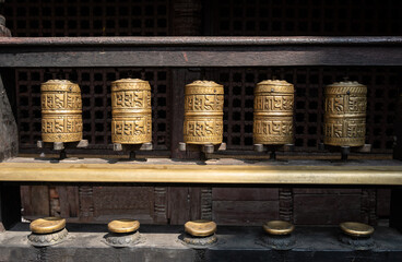 Rows of bronze prayer wheel in Buddhist temple in Kathmandu city of Nepal.
