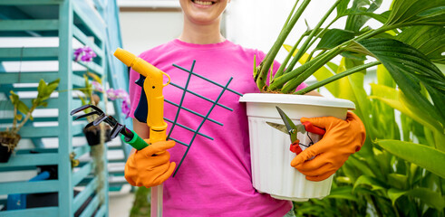 A young woman takes care of the garden, waters, fertilizes and prunes plants - 790586709