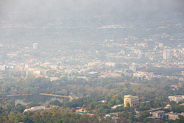 blurry backdrop of Chiang Mai's cityscape filled with burning and smog caused by wildfires during...