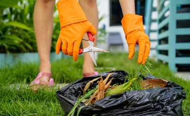 A young woman takes care of the garden and cutting grass - 790588749
