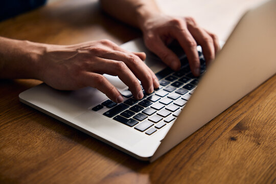 Closeup of man typing on laptop