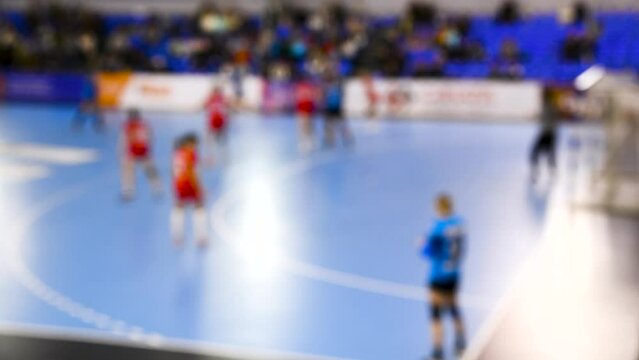 A women's sports team plays indoor handball. Blurry. Blurry background of a handball competition.