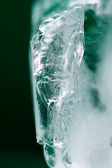Chrystal clear frosty textured natural ice block in cold light green tones, isolated on black...
