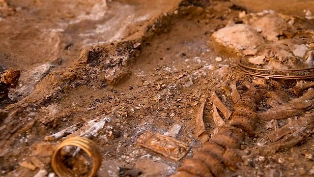 Archaeological excavations of ancient tombs. The remains of a human skeleton, household utensils, jewelry and jewelry found in an ancient tomb. The work of archaeologists