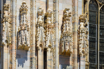 The exterior of the Cathedral Duomo di Milano, dedicated to St Mary of the Nativity, with Gothic style. Imposing architectural details close-up. View, details, architectures and embellishments. Italy.