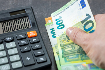 Euro banknotes, Calculator and money file, financial settlements, household budget, taxes, European Union currency exchange rate, financial analysis, economic and business concept