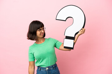 Youing woman holding a question mark icon and having doubts