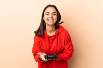 Young brunette mixed race woman playing with a video game controller over isolated background...