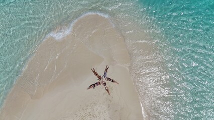 People are lying on the beach with white sand.