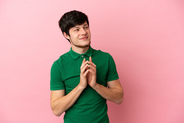 Young Russian man isolated on pink background scheming something - obrazy, fototapety, plakaty