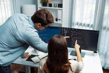 Team skilled developers program coding discussing creative website planning software project on two screen monitor's full stack data analyzing design at office with back side view concept. Postulate.