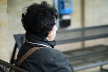 Elderly Woman Waiting Alone at a Train Station