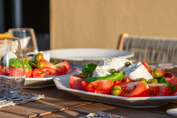 A sun kissed table presents a classic Caprese salad, with Mozzarella cheese, juicy tomatoes, green...