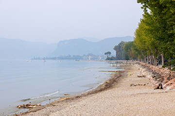 A leisurely stroll awaits along the mist-veiled promenade between Lazise and Bardolino on Lake...
