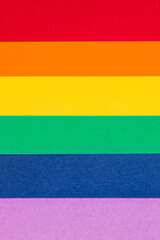 A vertical image showcasing a handmade representation of DIY gay pride flag, composed of brightly...