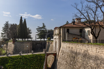 The main bridge entrance to the historical Brescia castle in Lombardy, with a moat, is captured in...