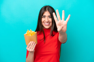Young caucasian woman catching french fries isolated on blue background happy and counting four...