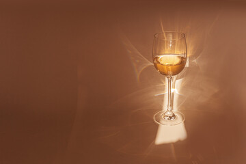 Sunbeam falls on glass of white wine, drink sparkles in sunlight, still life with wineglass of...