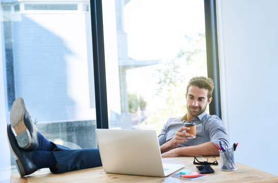 Smile, business man and work on laptop in desk at office in startup company as architect. Entrepreneur, feet on table and research for ideas, planning and internet for creativity or project