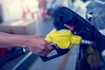 Hand refilling the white pickup truck with fuel at the gas station. Oil and gas energy. Fill a...