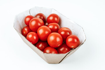 Cherry tomatoes in a cardboard box on a white background.