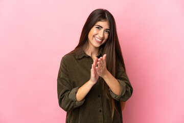 Young caucasian woman isolated on pink background applauding after presentation in a conference