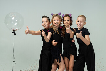 two curly-haired girls and two boys engaged in ballroom dancing show a thumbs up, everything is ok