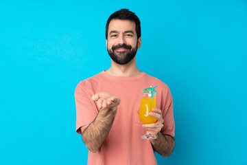 Young man over holding a cocktail over isolated blue background holding copyspace imaginary on the...