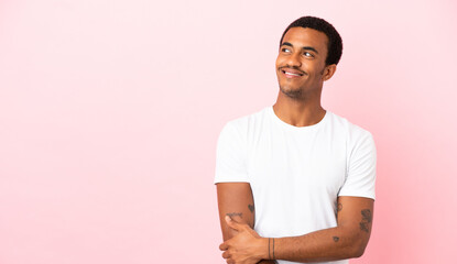 African American man on copyspace pink background thinking an idea while looking up