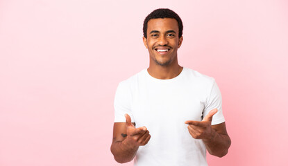 African American man on copyspace pink background pointing to the front and smiling