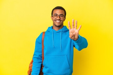 African American student man over isolated yellow background happy and counting four with fingers