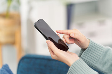 リビングでスマートフォンを操作する女性